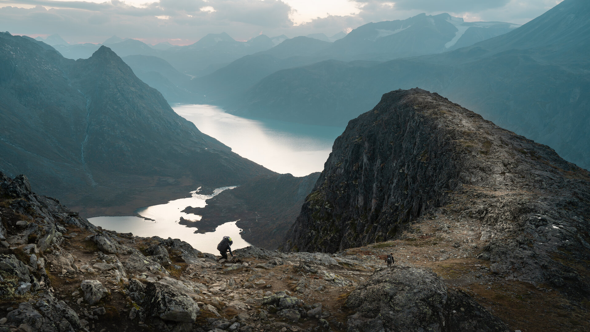 Wanderer auf Berggrat ueber See